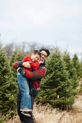 Parent and son outside beside a tree