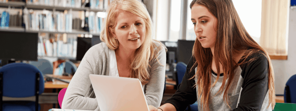 Two women talking and looking at a report together