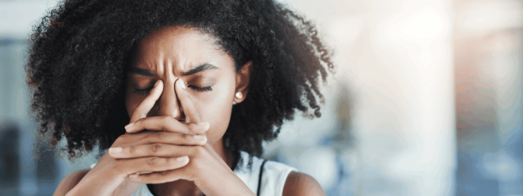 Woman holding head, clearly uncomfortable and frustrated