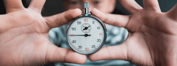 Close up photo of timer held between child's fingers