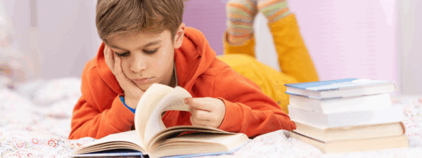 Boy laying on bed reading