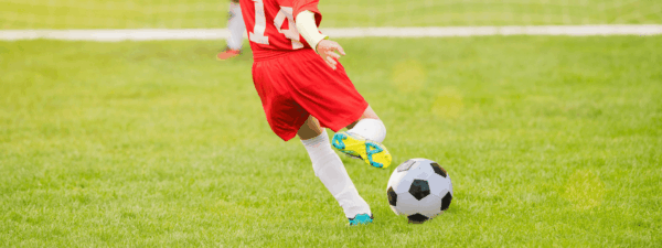 Image of child kicking soccer ball