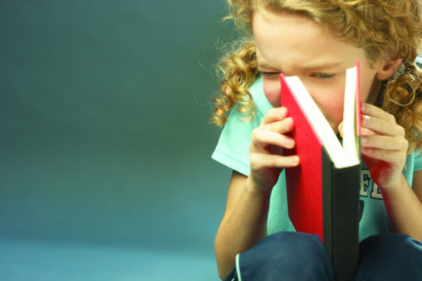 Girl peeking into opened book