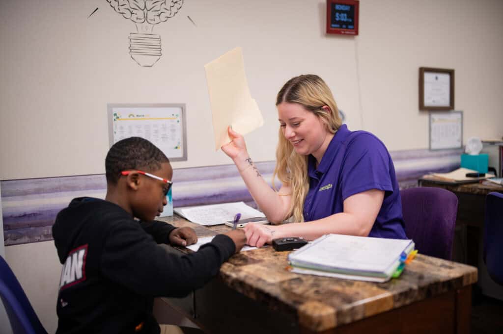 February newsletter - Trainer Anna working on reading with her student. 