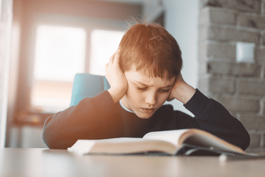 Boy at table learning by reading
