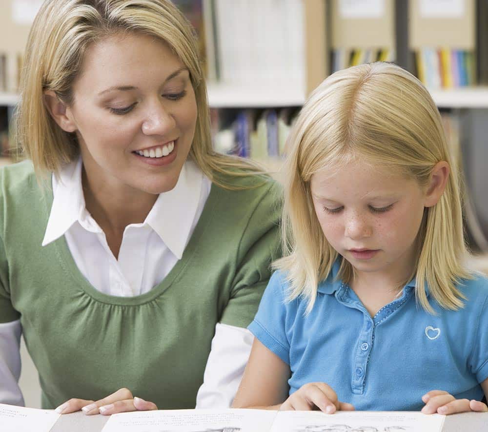 Student in class reading with teacher